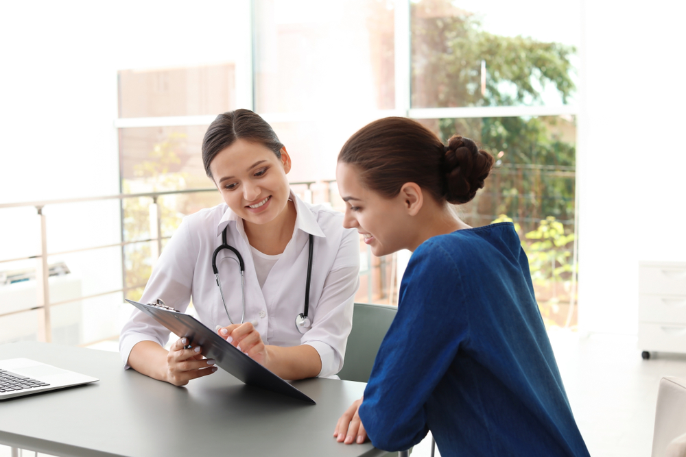 Young,Doctor,Consulting,Patient,In,Modern,Hospital